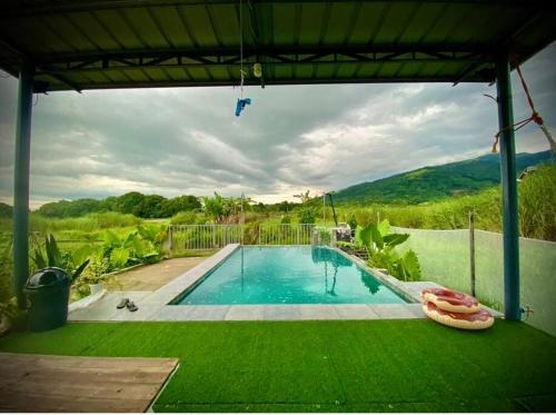 a swimming pool in a yard with a green lawn at Casita Blanca Jala-Jala - Tiny House & Farm Stay in Jalajala