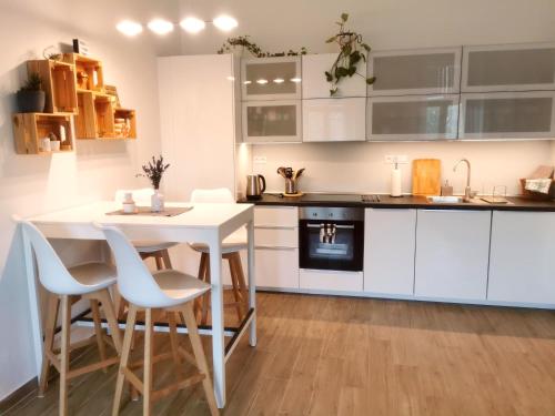 a kitchen with white cabinets and a white table and chairs at CozyHome in Old Town, Presidential apartment in Bratislava