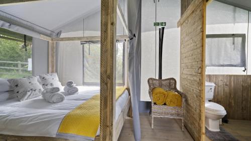 - une chambre avec un lit et des toilettes dans l'établissement Finest Retreats - The Herdwick Safari Tent, à Hertford