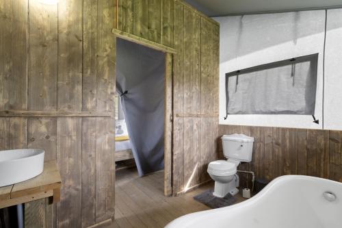 La salle de bains est pourvue d'une baignoire, de toilettes et d'un lavabo. dans l'établissement Finest Retreats - The Herdwick Safari Tent, à Hertford