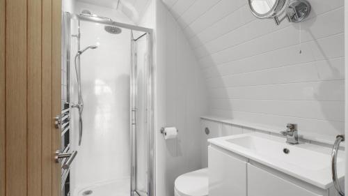 a white bathroom with a shower and a sink at Finest Retreats - The Highland Camping Pod in Hertford