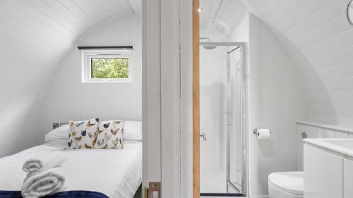 a white bedroom with a bed and a bathroom at Finest Retreats - The Chicken Coop in Hertford