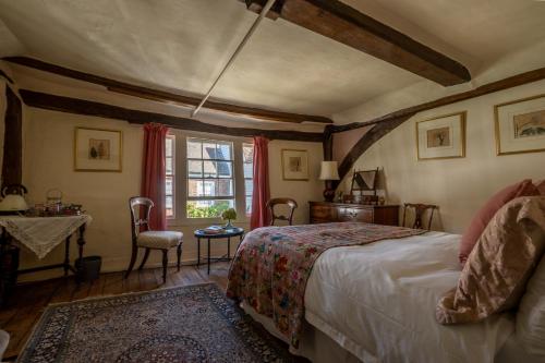 1 dormitorio con cama, mesa y ventana en The House with Two Front Doors en Rye