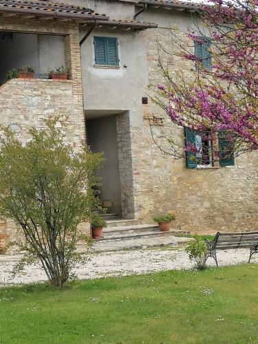 a stone building with a bench in front of it at Fattoria di Rigone in Coltavolino