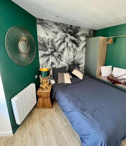 ショレにあるAppartement de charme - Cholet Centreの青いベッドと緑の壁が備わるベッドルーム1室が備わります。