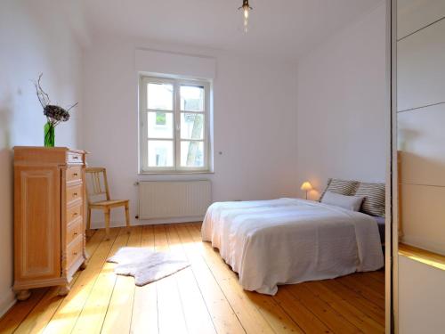 a bedroom with a bed and a dresser and a mirror at Entspanntes Wohnen in der Nähe des Baldeneysee in Essen