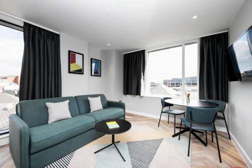 a living room with a green couch and a table at Staycity Aparthotels Dublin City Centre in Dublin