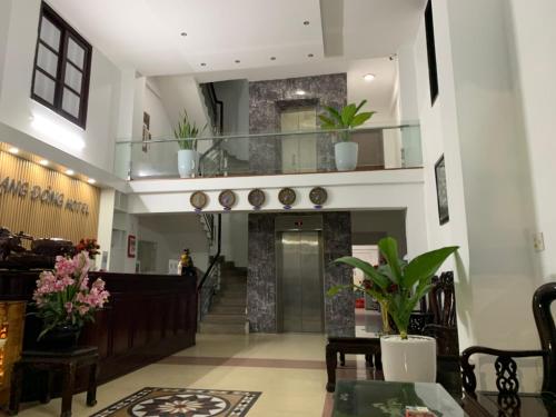 a lobby of a building with a staircase with plants at Rang Dong Hue Hotel in Hue