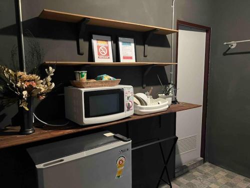 a microwave sitting on a shelf with a refrigerator at 3l9B Chiangmai Gate Best location 3 bedrooms apartment in Chiang Mai