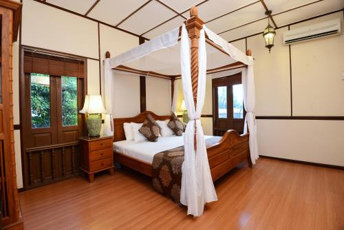 een slaapkamer met een hemelbed in een kamer bij LaVilla By Holiday Villa Cherating in Cherating