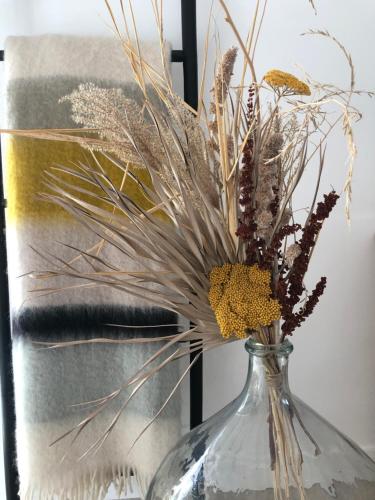 a clear glass vase with dried flowers in it at Belle villa rétaise 4 étoiles avec piscine chauffée in La Couarde-sur-Mer