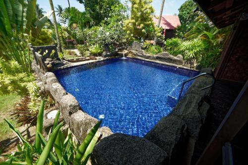 a swimming pool in the middle of a garden at LaVilla By Holiday Villa Cherating in Cherating