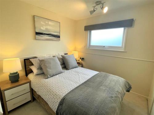a bedroom with a bed and a window at 126 Hemsby Holiday Chalet, Convenient for sandy beach in Hemsby