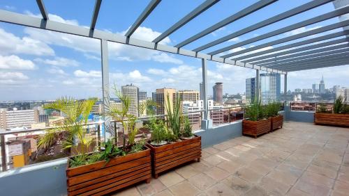 einen Balkon mit Pflanzen und Stadtblick in der Unterkunft Hotel Mokka City in Nairobi