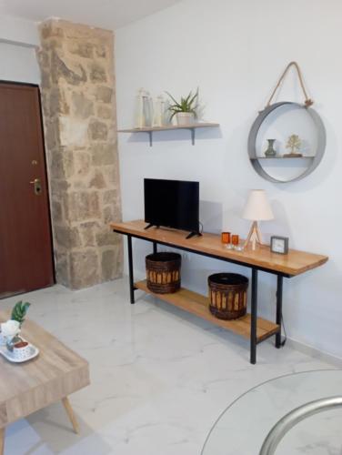 a living room with a desk with a television at STONEHOUSE & CASA AL SOLE e AL MARE in Nea Roda