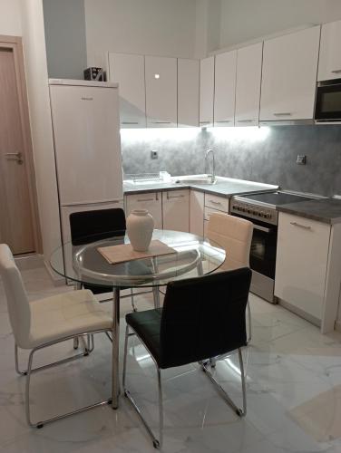 a kitchen with a glass table and chairs in it at STONEHOUSE & CASA AL SOLE e AL MARE in Nea Roda