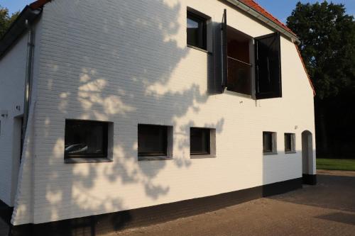 a white building with black windows on the side of it at WijkD in Leende