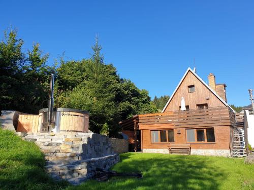 a house with a stone wall in front of it at Horský apartmán Draps in Ostružná
