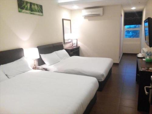 Habitación de hotel con 2 camas y escritorio en DM Hotel, en Kota Kinabalu