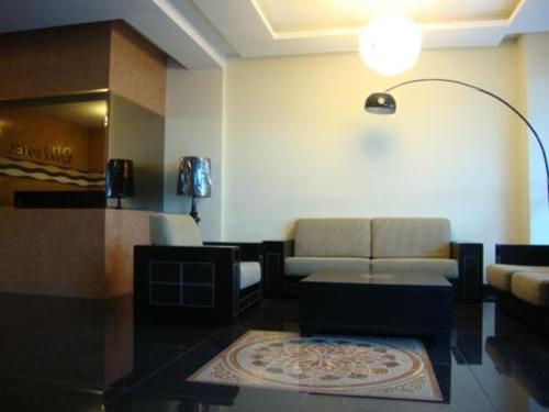 DM Hotel في كوتا كينابالو: غرفة معيشة مع أريكة وطاولة