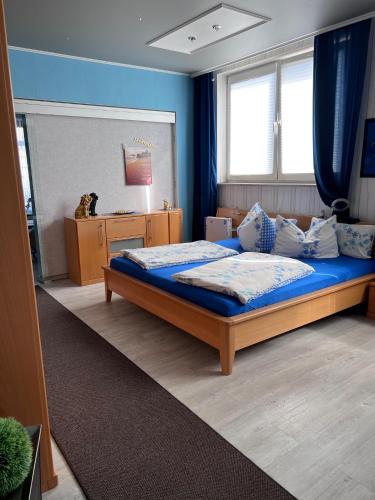 a bedroom with a large bed with blue walls at Ferienwohnungen am "Spiel-emagazin" in Halberstadt