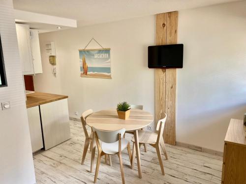 una cucina e una sala da pranzo con tavolo e sedie di Charmant appartement rénové 4 couchages Arcachon centre ad Arcachon