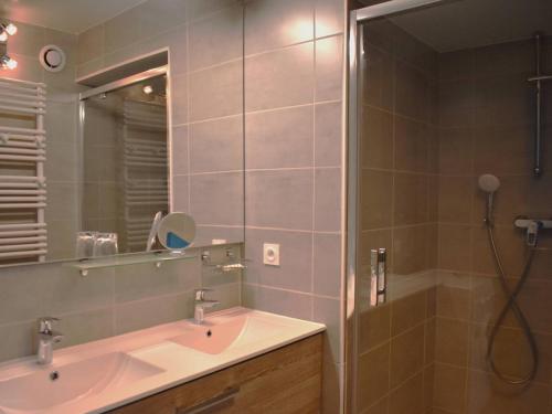 une salle de bain avec un lavabo et une douche avec un miroir dans l'établissement Appartement Spacieux 4 Pièces en Centre-Ville avec Cuisine Équipée et Chambres Confortables - FR-1-580-28, à Font-Romeu-Odeillo-Via