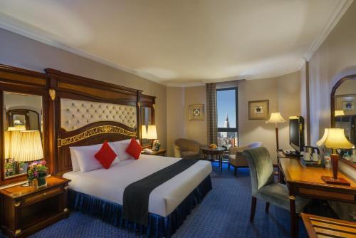 リヤドにあるMena Andalusia Riyadhの大きなベッドとデスクが備わるホテルルームです。