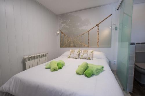 a white bed with two lime green pillows on it at For You Rentals CHALET SIERRA GUADARRAMA - LA PONDEROSA PON351 in Manzanares el Real