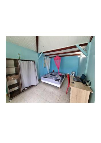 a room with a bedroom with a bed and a desk at VILLA AICHY in Rabi
