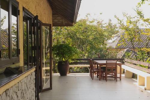 a patio with a table and chairs on a balcony at Villa Khao Phaengma in Wang Nam Khieo