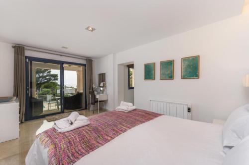 a bedroom with a large bed with two towels on it at 2550 Lichtdurchflutete Villa in Santa Ponsa Nova in Santa Ponsa