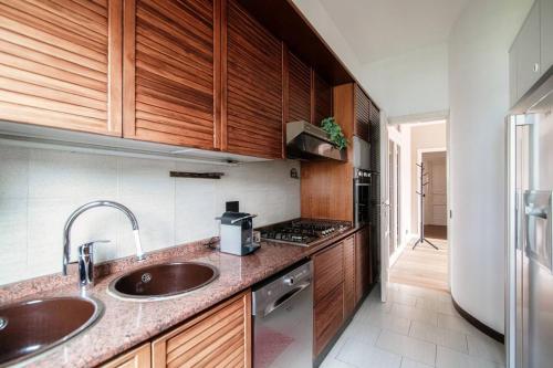una cocina con 2 lavabos y armarios de madera en Villa Sofia, en Como