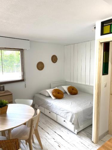 une chambre blanche avec un lit et une table dans l'établissement Charmant appartement rénové 4 couchages Arcachon centre, à Arcachon