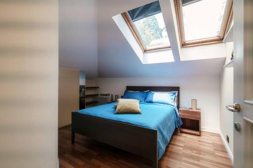 1 dormitorio con 1 cama con sábanas azules y 2 ventanas en Villa Sofia, en Como