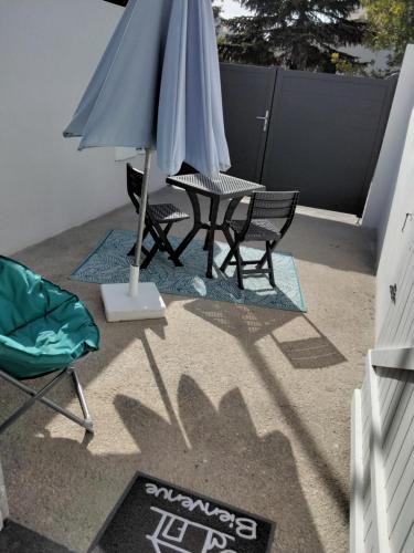 un patio avec deux chaises et un parasol dans l'établissement Studio indépendant, à Fouras