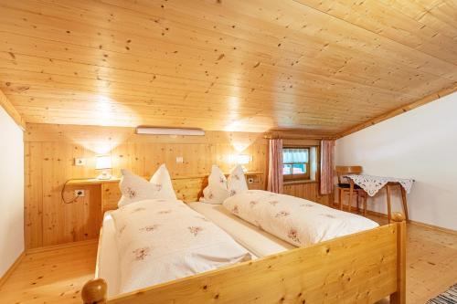 2 łóżka w pokoju z drewnianym sufitem w obiekcie Ferienwohnung Jägermeister w mieście Sankt Martin bei Lofer