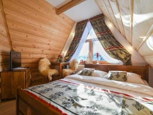 a bedroom with a bed and a window in a cabin at Magurskie Bywanie in Witów