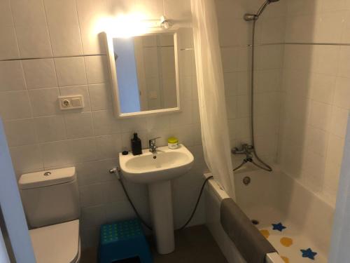 a bathroom with a sink and a toilet and a mirror at Apartamento Calafat, a 2 minutos a pie de Cala Llobeta in Calafat
