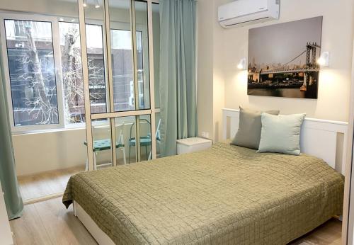 - une chambre avec un lit et une grande fenêtre dans l'établissement ~ The Blue Apartment ~ 1BD with a Cozy Balcony, à Varna