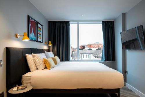 a bedroom with a large bed with a large window at Staycity Aparthotels Dublin City Centre in Dublin