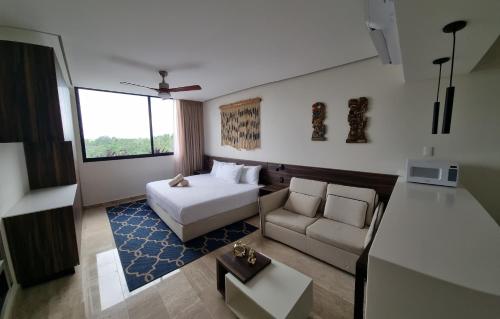 une chambre d'hôtel avec un lit et un canapé dans l'établissement Acogedor estudio 305 wifi netflix Tulum Aldea Zama, à Tulum