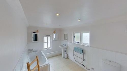 a white bathroom with a sink and a toilet at Cambridge House in Sidmouth