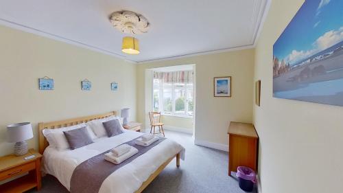 1 dormitorio con cama y ventana grande en Cambridge House en Sidmouth