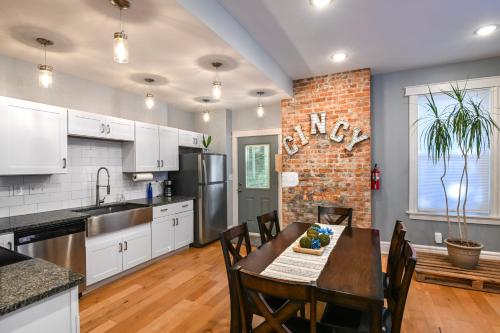 a kitchen with a table and a brick wall at Cincy Dream! Walk to Zoo, UC, hospitals, and Short Vine district in Cincinnati