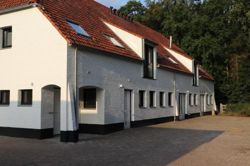 ein weißes Gebäude mit rotem Dach in der Unterkunft WijkD in Leende