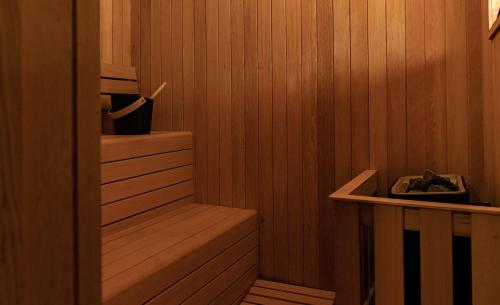 a sauna with a wooden paneled wall and a wooden shelf at Amaya Life Kasauli in Kasauli