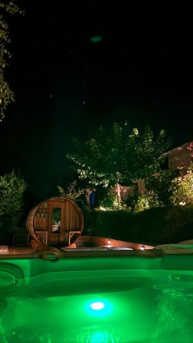 a green light in front of a pool at night at Gîte de charme 5 étoiles pour couple avec sauna et jacuzzi extérieurs privatifs in Peaugres