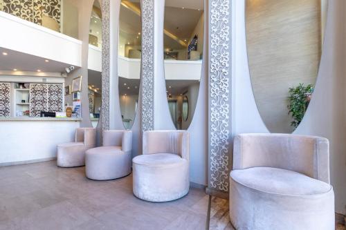 a lobby with white chairs and a staircase at Agripas Boutique Hotel in Jerusalem
