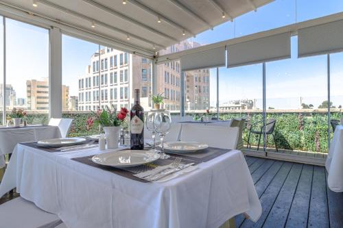 uma mesa branca com uma garrafa de vinho na varanda em Agripas Boutique Hotel em Jerusalém